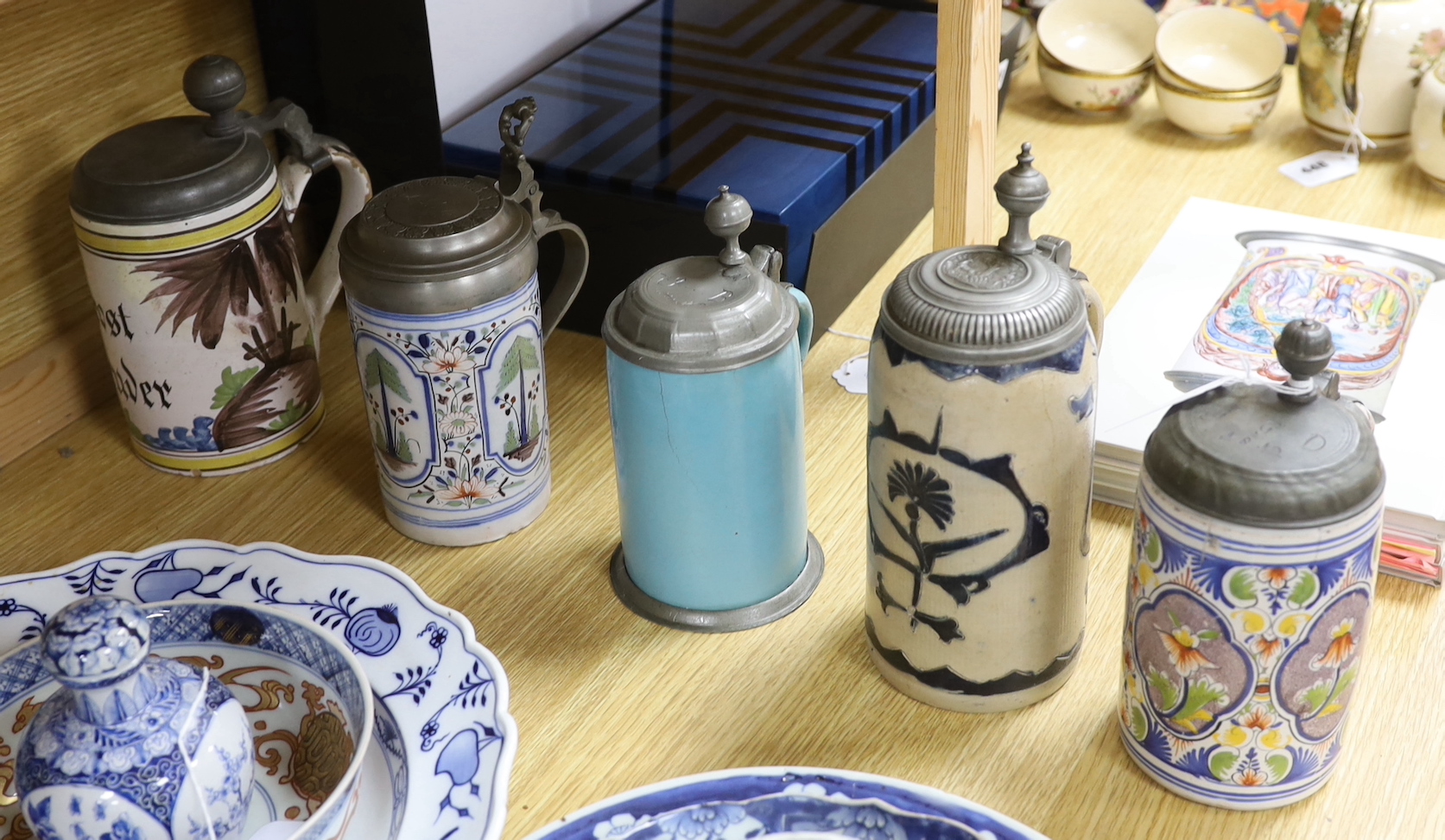 Four 18th century German faience lidded tankards and a salt glazed tankard, all with hinged pewter lids, tallest 25cm, (5)